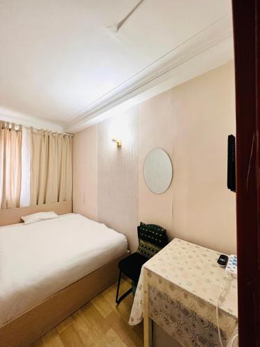 a small bedroom with a bed and a table at Khongor Guest house & Tours in Ulaanbaatar