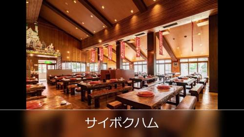 un restaurante con mesas de madera, bancos y ventanas en Le Ciel Spa & Resort -Adlt only-, en Tsurugashima