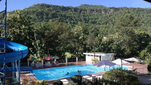 una piscina con una montaña en el fondo en Phubachiang Golf and Resort Pakse, en Pakse