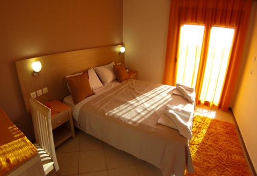 Un dormitorio con una cama grande y una ventana en Villa Decauville, en Gerakini