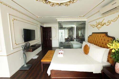 a bedroom with a large white bed and a television at Hoàng Gia Xa La Boutique Hotel in Hanoi