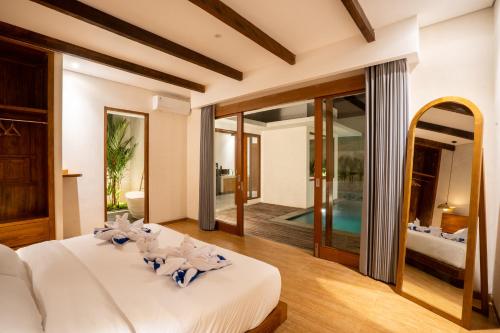 a bedroom with a large bed and a swimming pool at Atania Villa's Bingin in Uluwatu