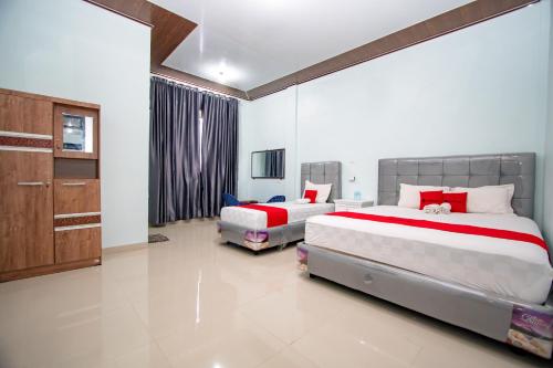 a bedroom with two beds and a cabinet at RedDoorz Syariah near Danau Lut Tawar Takengon in Takengon