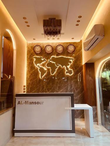 El mansour hotel apartmen 84 في المنصورة: لوبي وحائط عليه ساعات