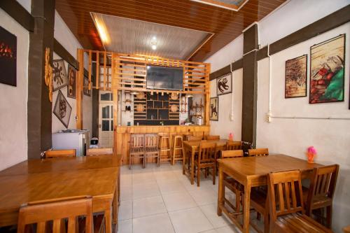 a dining room with wooden tables and chairs at RedDoorz Syariah near Danau Lut Tawar Takengon in Takengon