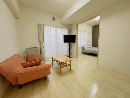 a living room with a chair and a table at 6-2新規OPEN　札幌駅から徒歩7分の良い場所！サービスアパートメントSAPPOROステーション6-2　ネット無料 in Sapporo
