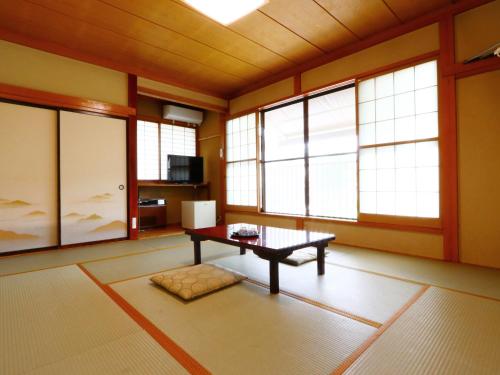 uma sala de estar com uma mesa e janelas em Takanoya em Yuzawa