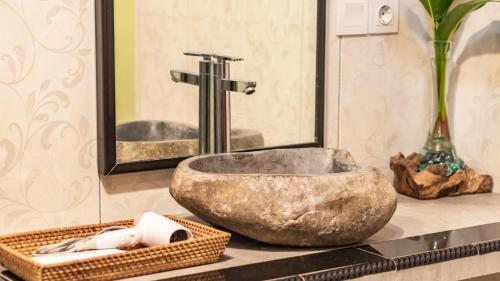 uma casa de banho com um lavatório de pedra e um espelho. em Maruan Sari em Ubud
