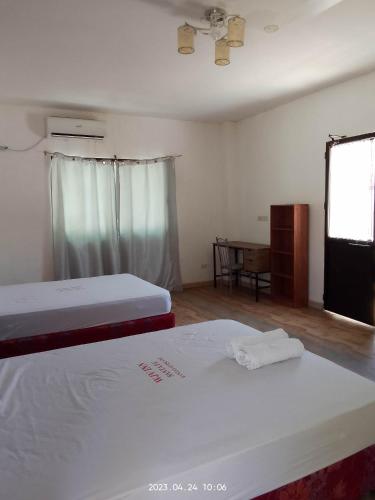 Zimmer mit 2 Betten und einem Tisch mit Fenster in der Unterkunft Wjv Inn Sta. Fe Bantayan in Ocoy