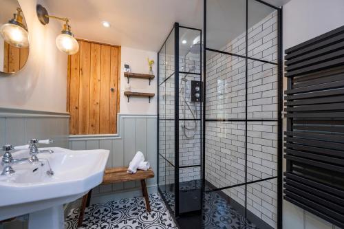 ein Badezimmer mit Waschbecken und Dusche in der Unterkunft Buttercup Cottage, Hartest in Hartest