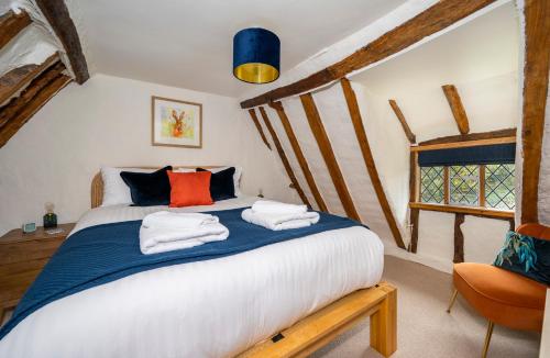 a bedroom with a bed with towels on it at Buttercup Cottage, Hartest in Hartest