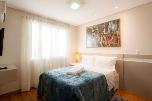 Un dormitorio con una cama y una ventana en Flores da Montanha 301B, en Gramado