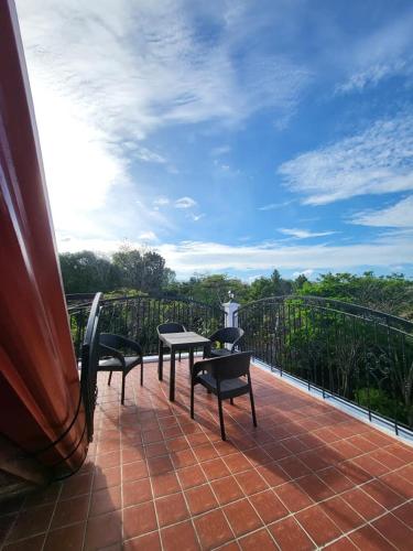 a patio with chairs and tables on a balcony at El Castillo Bed and Breakfast in Angono