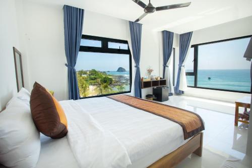 Schlafzimmer mit einem großen Bett und Meerblick in der Unterkunft Palm Beach Hotel Phú Yên 