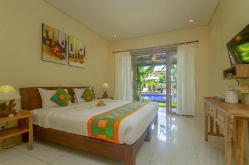 um quarto com uma cama grande e uma porta de vidro deslizante em KUDESA Homestay by Pramana Villas em Ubud