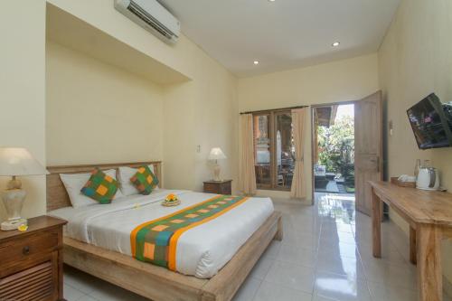 a bedroom with a bed and a television in it at Kudesa Bali in Ubud