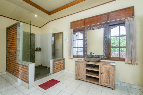 La salle de bains est pourvue d'une douche, d'un lavabo et d'un miroir. dans l'établissement KUDESA Homestay by Pramana Villas, à Ubud