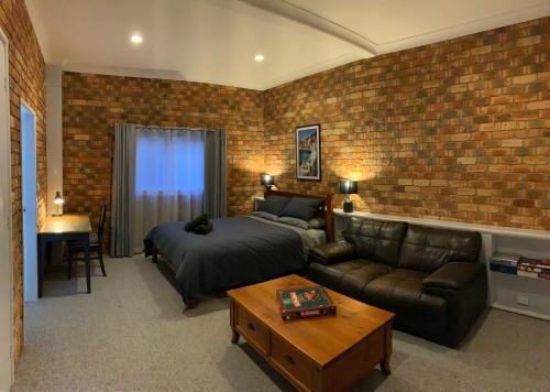 - une chambre avec un lit et un mur en briques dans l'établissement Ocean View, à Port Macquarie