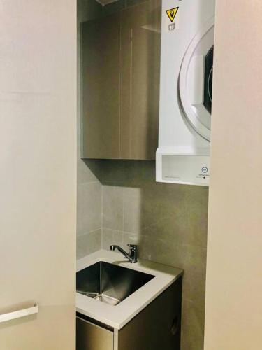 a kitchen with a sink and a microwave at Stunning Corporate Apartment WAT1011601 in Sydney