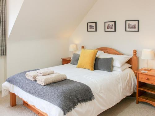 een slaapkamer met een groot wit bed met kussens bij Castleview West in Lochearnhead