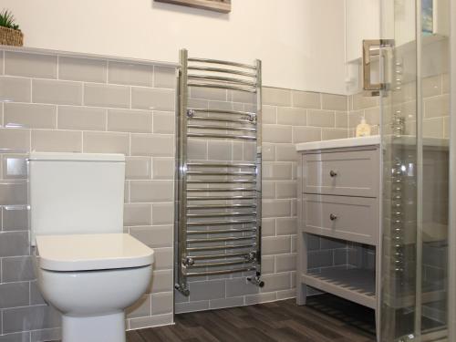 a bathroom with a toilet and a glass shower at Castleview West in Lochearnhead