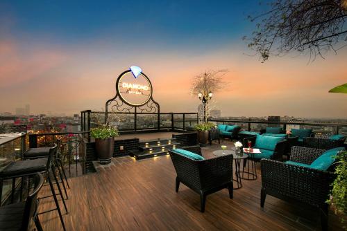 eine Dachterrasse mit Tischen und Stühlen und ein Schild mit Sharmaarma in der Unterkunft La Mejor Hotel & Sky Bar in Hanoi