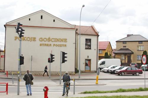 a group of people crossing a street in front of a building at Stara Poczta in Zambrów