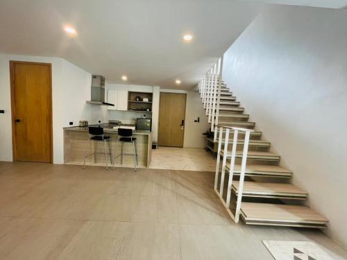 una escalera en una habitación con cocina y un asterisco de cocina en Replay Residences Samui, en Bangrak Beach