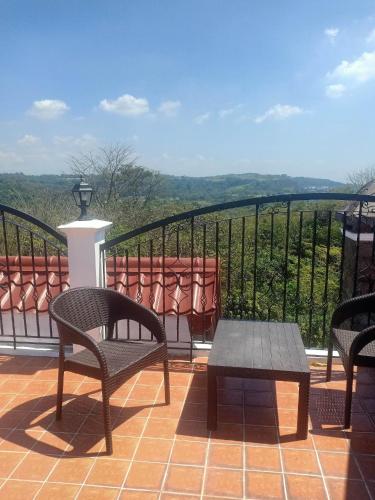 a balcony with chairs and a table and a view at El Castillo Bed and Breakfast in Angono