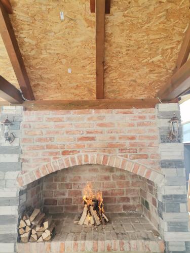 a brick fireplace with a fire in it at Apartman Sunny Lika in Gospić