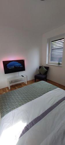 a bedroom with a bed and a flat screen tv at LA Studio in Maribor