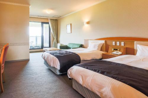 a hotel room with two beds and a window at SPA&HOTEL RESORT Furano La Terre in Nakafurano