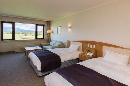 中富良野町にあるSPA&HOTEL RESORT ふらのラテールのベッド2台と窓が備わるホテルルームです。