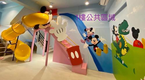 a room with a mickey mouse wall mural at Kaohsiung High Fun Hostel in Kaohsiung