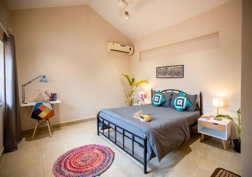 a bedroom with a bed and a rug at NomadGao Vila Nova - Comfort, Great Views, Fast WiFi & Interesting People in Anjuna
