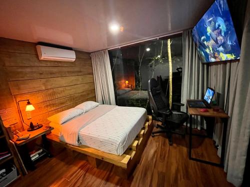 a bedroom with a bed and a desk and a window at Sweet Jungle in Quesada