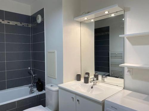 a bathroom with a sink and a toilet and a mirror at Studio Cosy à 10 min de Paris in Deuil-la-Barre