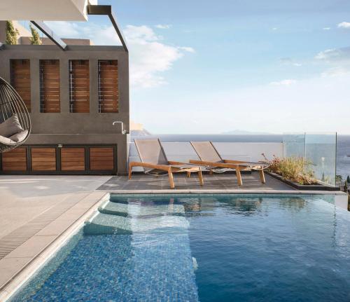a house with a swimming pool next to a house at Athens riviera beach villa in Anavissos