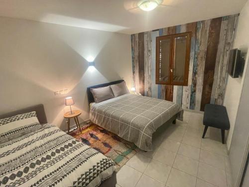 Villa spa, sauna et piscine couverte proche rivière Aveyron في Albias: غرفة نوم صغيرة مع سرير وطاولة
