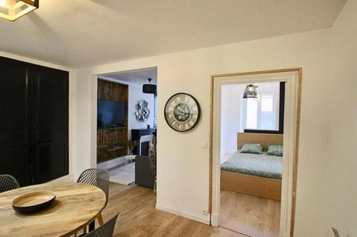 Habitación con cama, mesa y reloj en Appartement centre Brioude, en Brioude