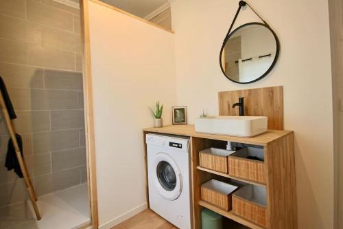 een badkamer met een wasmachine en een spiegel bij Appartement centre Brioude in Brioude
