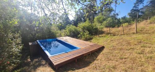 una piscina en una terraza de madera en un campo en Peña de Horeb, en Villa Serrana