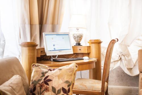 a desk with a computer on it with a chair at Hotel San Luca in Verona