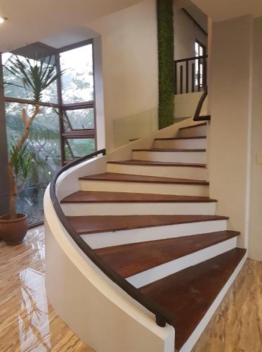 a staircase in a house with wooden floors and a window at MelSol Hotel in Bantay