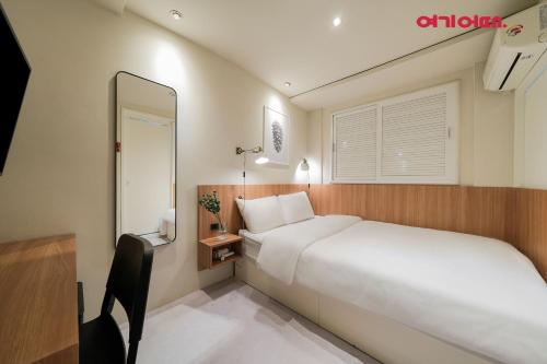 a bedroom with a large white bed and a mirror at Hotel Less Seoul in Seoul