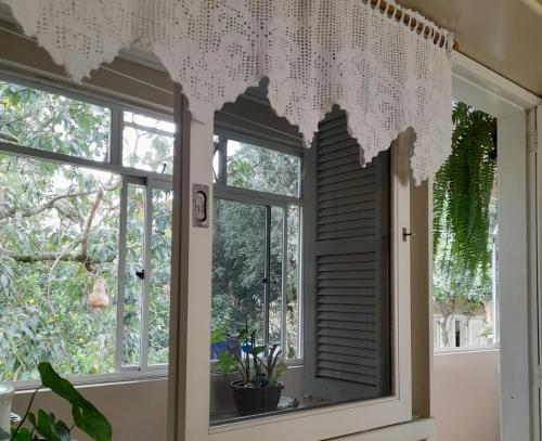 a window in a room with a curtain on it at Casa Vista do Vale próxima ao Vale dos Vinhedos in Bento Gonçalves