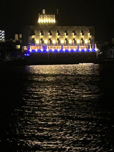 un edificio con luces en el agua por la noche en HOTEL　TRITON, en Itoman