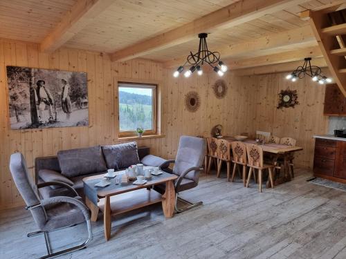 a living room with a couch and a table at Domki u Jacka - sauna bilard tenis air hockey piłkarzyki bawialnia plac zabaw in Czerwienne