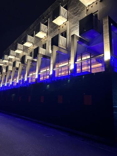 un edificio iluminado por la noche con luces azules en HOTEL　TRITON, en Itoman