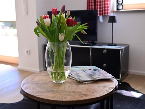 un vase de fleurs assis sur une table dans l'établissement FEWO RISSERKOGEL das Original mit großem Garten, à Bad Wiessee